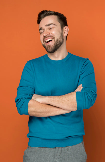 hombre sonriendo con los brazos cruzados