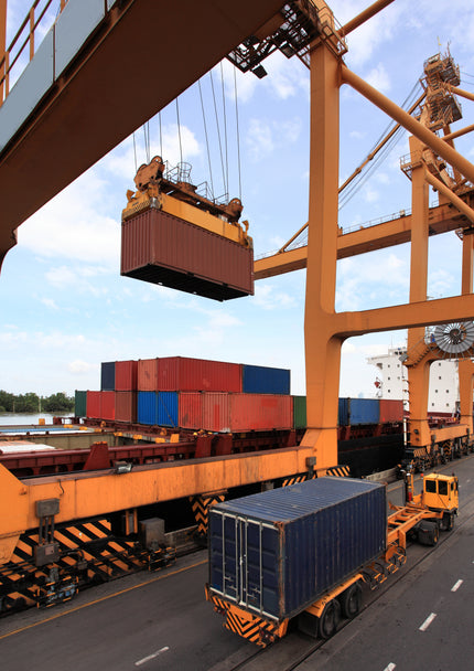 Puerto marítimo con grúa cargando contenedores en camiones